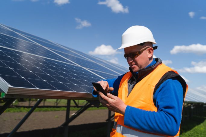 Arbeiter, der auf seinem Handy etwas nachschaut